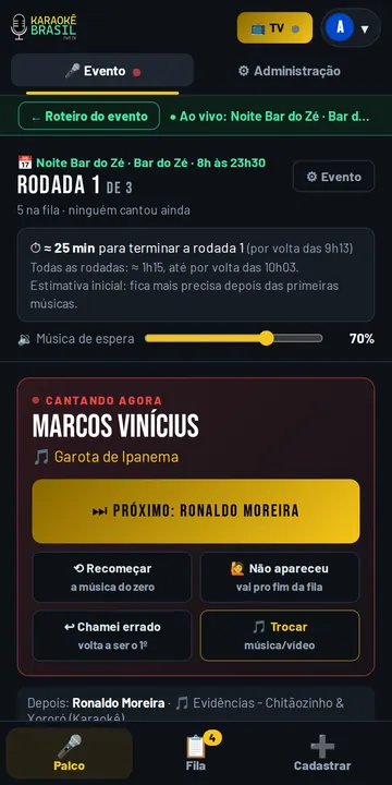 Apresentador comandando o karaokê pelo celular com o botão próximo cantor